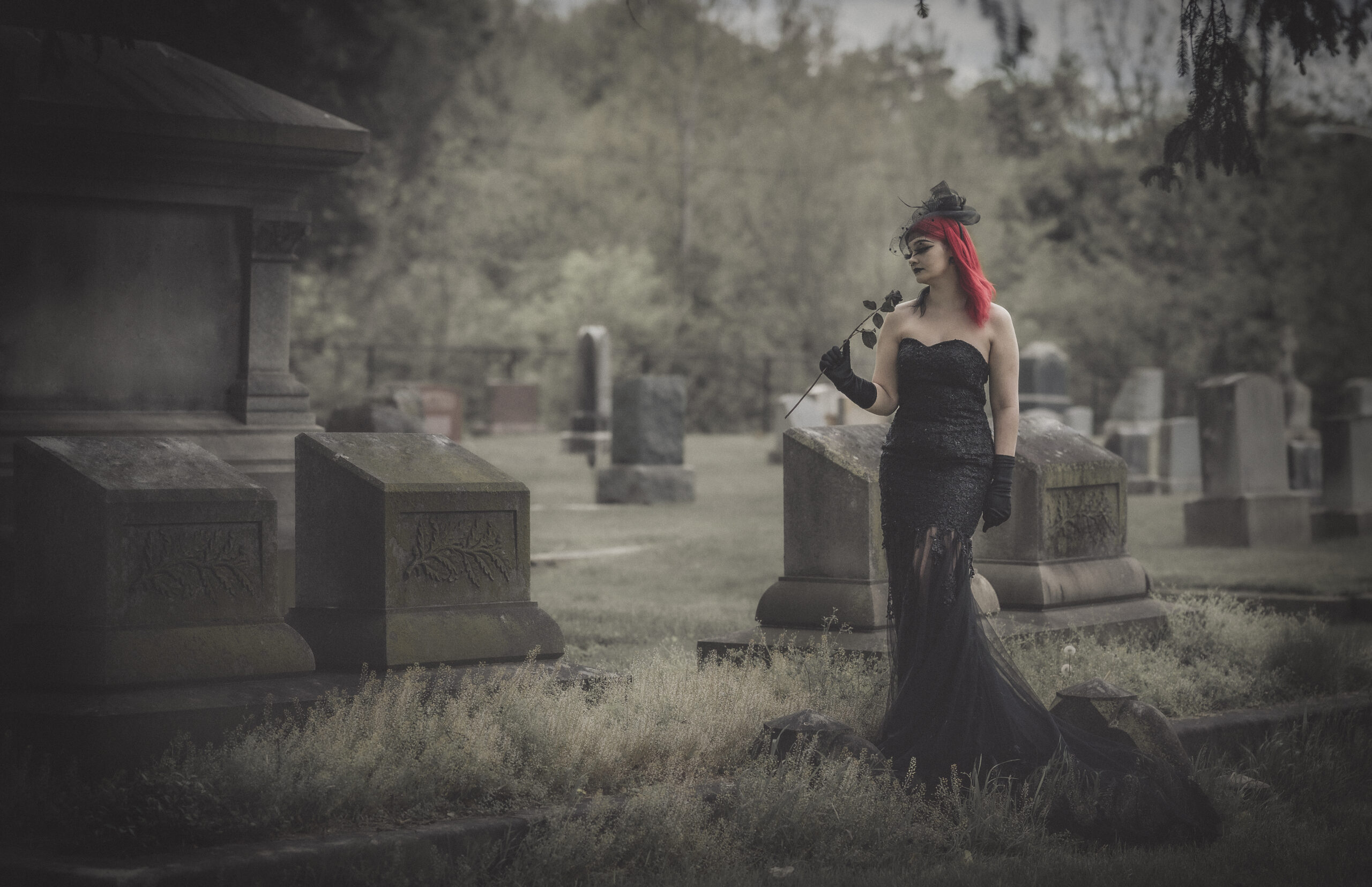 A woman in black mourns in a cemetery
